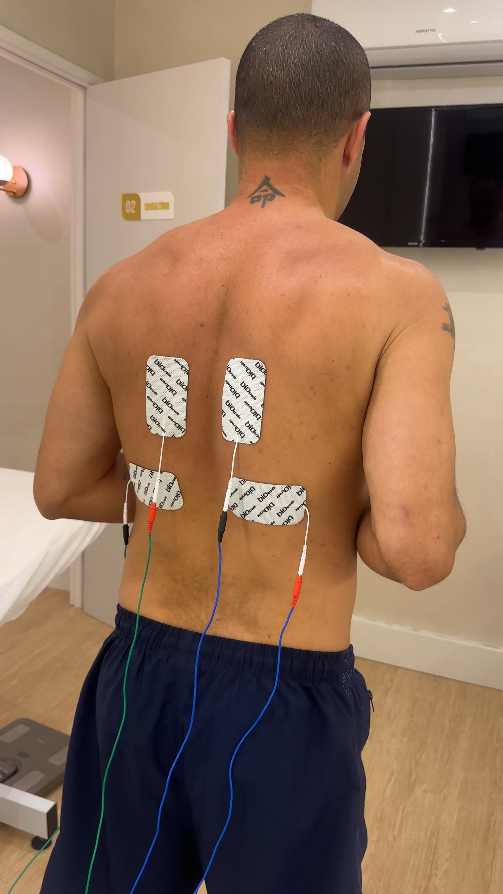 Pessoa em atendimento do Body Harmony com eletrodos nas costas